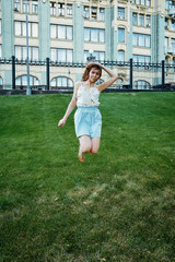 Fototapeta premium Pretty young girl sitting next to bike in grass and having a rest