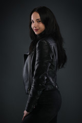 Girl in black leather jacket on gray background