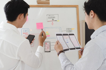 Creative Website development team sketching wireframe layout design for mobile responsive website...