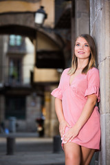 Young smiling woman near the stone wall  in historical center