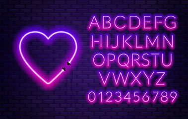 Neon alphabet with heart on brick wall background.
