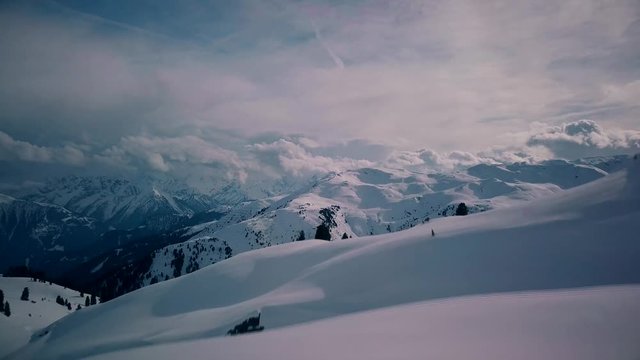 Aerial view on a group of people standing on top of mountain and observing beautiful panorama. Scenic panorama of valley appears.Drone is flying between people. Zillertal, Kaltenbach, Austria