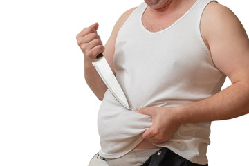A man with one hand holds the fat fold on his big belly, and in the other hand holds a knife.