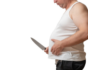 A man with one hand holds the fat fold on his big belly, and in the other hand holds a knife.