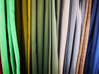 abbigliamento maglietti e pantaloni multicolori in gradazione appesi in esposizione