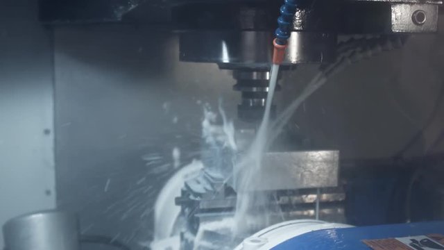 Process of drilling metal parts on an automatic milling machine with coolant. Milling metalworking process precision. Industrial cnc machining of metal detail by cutting mill. Milling machine.