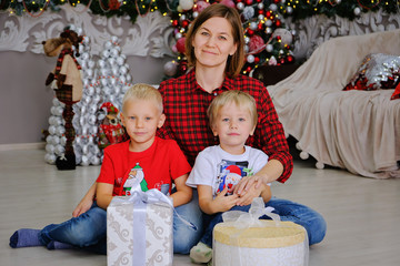 Mother and children with gifts near Christmas tree at home. Family concept.