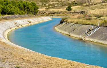 CANAL OF WATER IN A WALL OF CONCRETE IN THE SURFACE OF THE FIELD