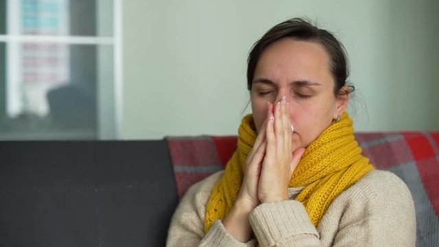 Sick Young Woman Blowing Nose at Home