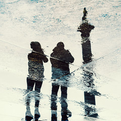 Reflection of couple in wet pavement front of Nelson's Column, Traflagar Square, London, UK - 230182938