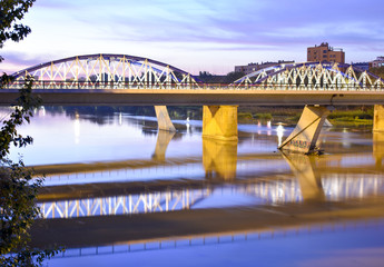 IRON BRIDGE OVER THE RIVER EBRO IN ZARAGOZA DURING THE SUNSET