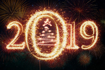 Happy new year 2019 and christmas tree written with Sparkle firework over the multicolors background, happy new year concept