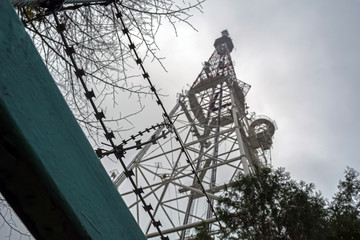 TV tower with telephone transmitters against a cloudy sky