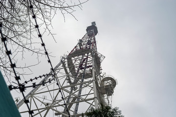 TV tower with telephone transmitters against a cloudy sky
