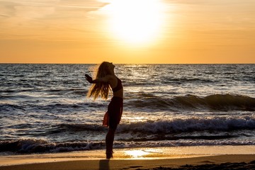 Tanzen befreit am Strand im Sonnenuntergang