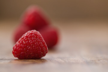 Ripe raspberries on wood background