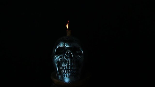 Halloween dark scary horror story ideas concept with jocker candle light and silver skull human isolated on black background