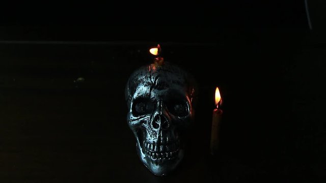 Halloween dark scary horror story ideas concept with jocker candle light and silver skull human isolated on black background