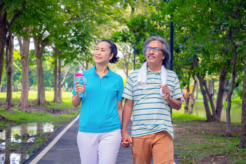 The old couple relax after jogging. They hold their hands and smile. They love and they are sweet.Sweetheart, Life style, Exercise ,Photo concept love and healthy.