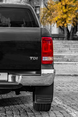 large SUV rear view. against a backdrop of granite steps and wood