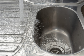 Spülbecken mit Wasser reinigen - Abfluss in Spültrog frei und sauber halte