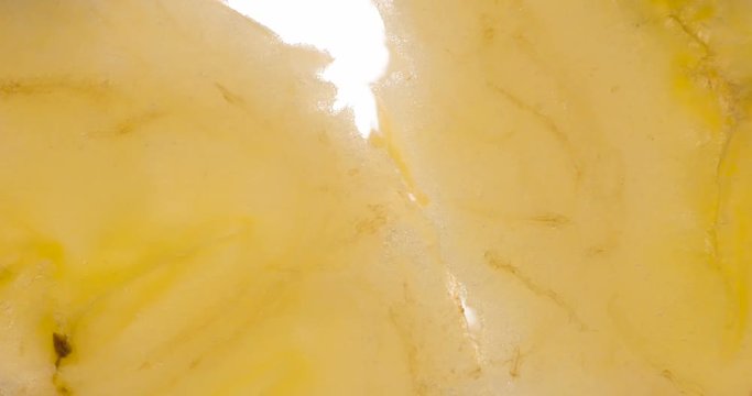 Compressing Two Banana Slices. The flesh of the banana is compressed and crushed close-up on a bright white background, creating a juicy splash of pulp and juice. Shooting at 120 fps