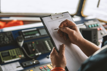 Marine navigational officer or chief mate on navigation watch on ship or vessel. He fills up...