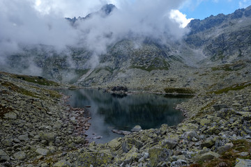 Naklejka na ściany i meble peak of Rysy mountain covered in mist. autumn ascent on hiking trails