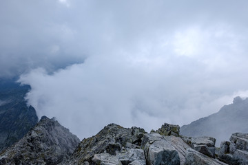 peak of Rysy mountain covered in mist. autumn ascent on hiking trails