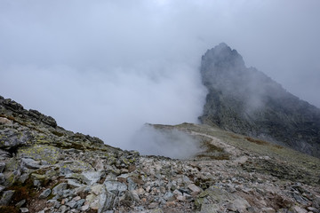 Fototapeta premium peak of Rysy mountain covered in mist. autumn ascent on hiking trails