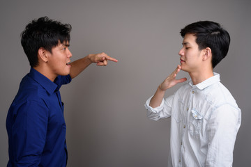 Two young handsome Asian men having argument