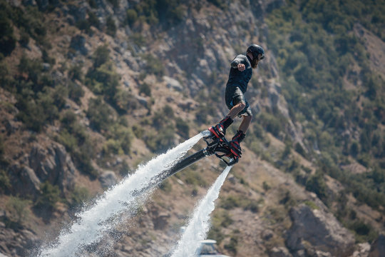 Flyboarding and seariding on the Sea near the mountain island. Water summer extreme sports.