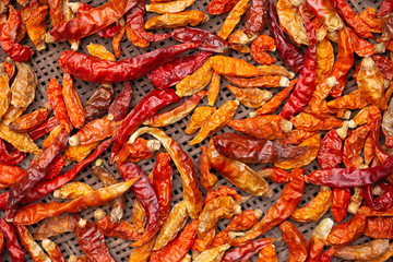 Dried red and yellow chilli on threshing basket