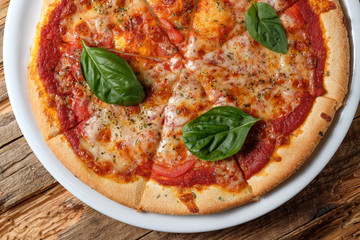 Pizza margherita with leaves of fresh basil