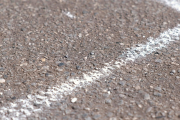Drawing line with chalk on asphalt outdoor.
