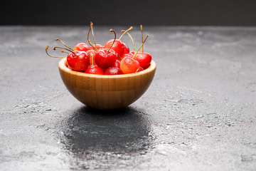 Photo of red cherry in wooden cup