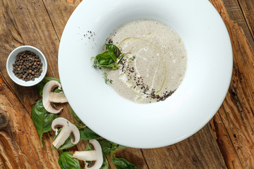 The mushroom soup. Leaves of basil and slices of champignons