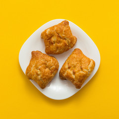 Freshly baked butter croissant on yellow colored background, top view