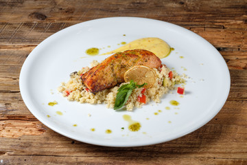 Baked salmon slice with couscous on a white plate