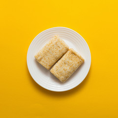 Fototapeta na wymiar Plate with tasty pancakes on yellow background, top view, flat lay
