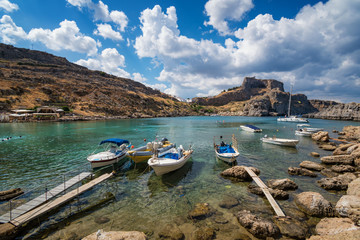 Fototapeta na wymiar St. Paul bay with boats, Lindos acropolis in background (Rhodes, Greece).