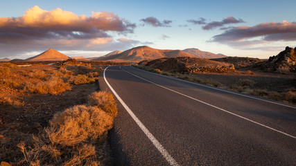 beautiful winding road through a volcanic mountainous landscape at sunset
