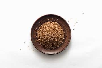 Buckwheat cereal grains on the white background, top view, flat lay