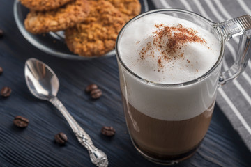 Glass cup of coffee latte on wooden table. Closeup