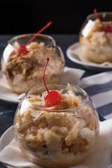 Napoleon cake with cocktail cherry in a glass bowl