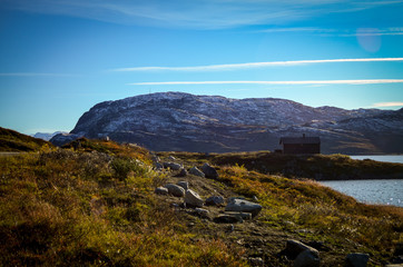 lonely wooden house in rough norwegian landscape