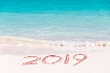 Fototapeta na wymiar 2019 written on the sand of a beach, travel 2019 new year concept