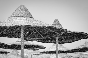 Wooden sun umbrella on beach in black and white