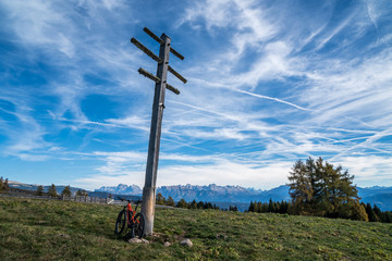 Fototapeta na wymiar einsames Fahrrad lehnt an Wetterkreuz mit Dolomitenblick