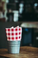 Serviettes en papier à carreaux rouge blanc dans un pot en métal